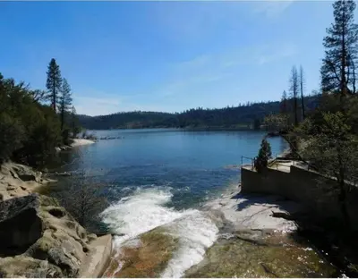 a view of a large lake with snow on the shore at Rustic Chapparal Cabin at Bass Lake Heights in Oakhurst