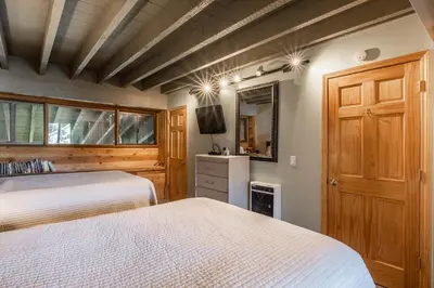 a bedroom with two beds and a flat screen tv at Updated 5 Bedroom 3 bathroom townhome Slopeside at 1849 Condos 671 sleeps 10 in Mammoth Lakes