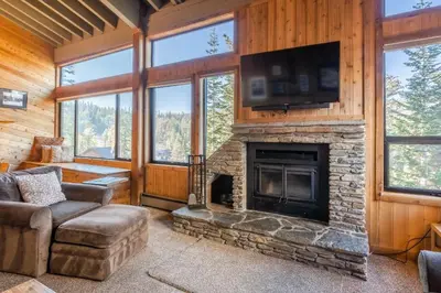 a living room with a stone fireplace with a flat screen tv at Updated 5 Bedroom 3 bathroom townhome Slopeside at 1849 Condos 671 sleeps 10 in Mammoth Lakes