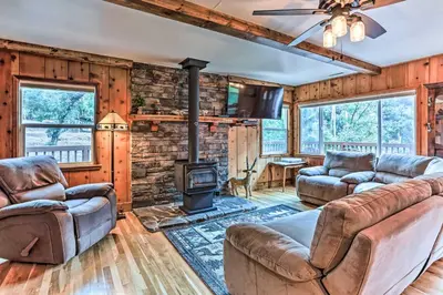 a living room with leather furniture and a woodburning stove at Rustic Oakhurst Retreat Less Than 4 Mi to Bass Lake! in Oakhurst