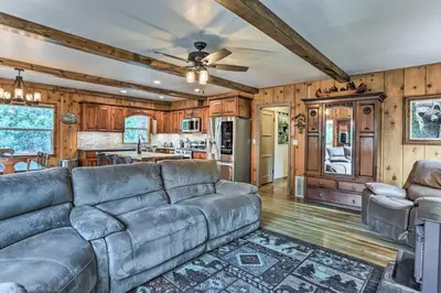 a living room with a couch and a kitchen at Rustic Oakhurst Retreat Less Than 4 Mi to Bass Lake! in Oakhurst