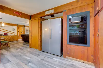 a kitchen with a refrigerator and a dining room at 1 Mi to Lake Hot Tub Haven in Pollock Pines! in Pollock Pines