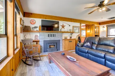a living room with a couch and a fireplace at 1 Mi to Lake Hot Tub Haven in Pollock Pines! in Pollock Pines