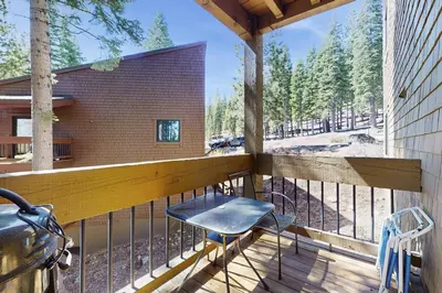 a balcony with a table and a chair on it at Coyote Fork Escape in Truckee