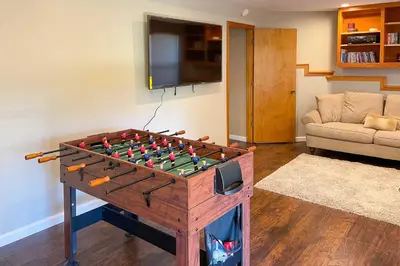 a living room with a foos ball on a table at Deck and Grill Mtn Haven in Stanislaus Natl Forest in Arnold