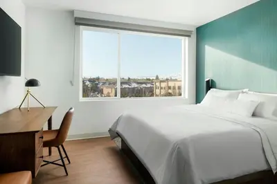 a bedroom with a bed and a desk and a window at Element Reno Experience District in Reno