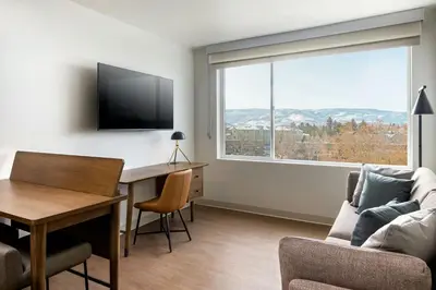 a living room with a desk and a large window at Element Reno Experience District in Reno