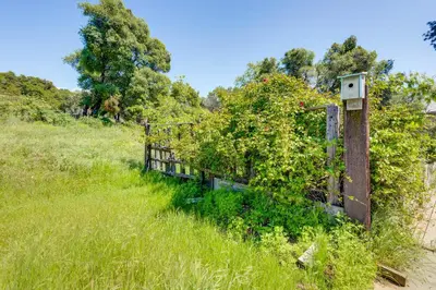 an old fence in the grass next to a field at 33 Mi to Yosemite Secluded Mariposa Retreat! in Mariposa