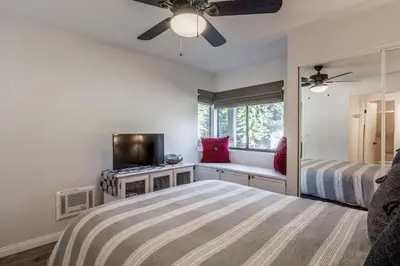 a bedroom with a bed and a flat screen tv at Highly updated 1 Bedroom plus den, 2 bath Crestview Unit 5 Sleeps up to 4 located near Canyon Lodge in Mammoth Lakes