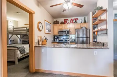 a kitchen with a bar and a bunk bed at Ski in Ski Out Juniper Springs Lodge #351 Luxury Slope-side 2 Bedrm 2 Bath End Unit! in Mammoth Lakes