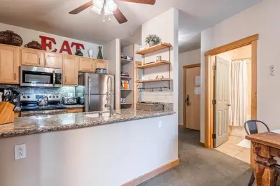 a kitchen with a stainless steel refrigerator and a counter at Ski in Ski Out Juniper Springs Lodge #351 Luxury Slope-side 2 Bedrm 2 Bath End Unit! in Mammoth Lakes