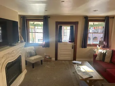 a living room with a couch and a fireplace and a door at Historic Washington St Balcony in Sonora