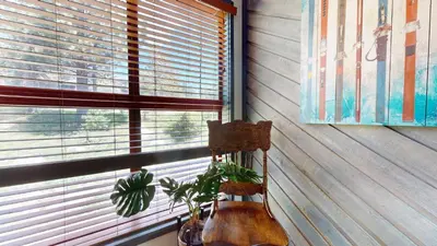 a room with a window with a plant in a chair at Aspen Creek #115 condo in Mammoth Lakes