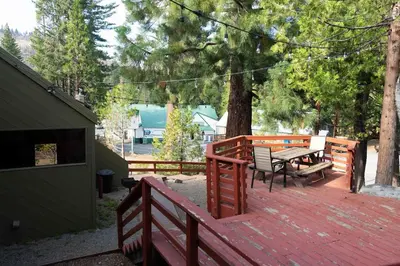 a wooden deck with a table and benches on it at Miners Suite-Centrally Located in Shaver Lake in Shaver Lake