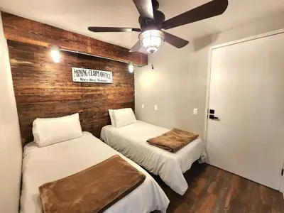two beds in a room with a ceiling fan at Miners Suite-Centrally Located in Shaver Lake in Shaver Lake