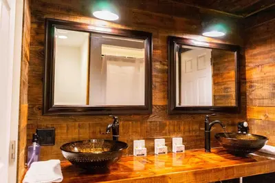 two sinks in a bathroom with two mirrors at Miners Suite-Centrally Located in Shaver Lake in Shaver Lake