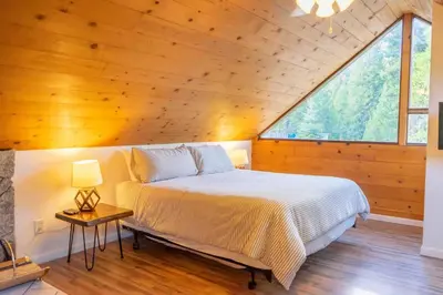 a bed in a room with a large window at Hawks Nest- Perfect Getaway in Shaver Lake in Shaver Lake