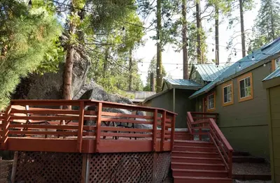 a set of stairs leading to a house with a fence at Hawks Nest- Perfect Getaway in Shaver Lake in Shaver Lake