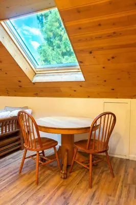 a table and two chairs in a room with a skylight at Hawks Nest- Perfect Getaway in Shaver Lake in Shaver Lake