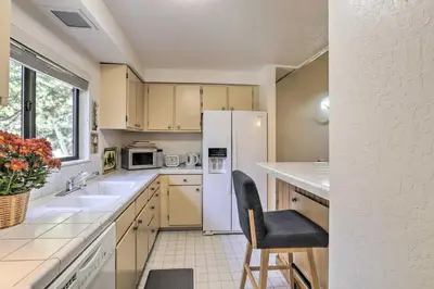 a kitchen with a white refrigerator and a chair in it at 1 Mi to Diamond Peak Skiing Incline Village Condo in Incline Village