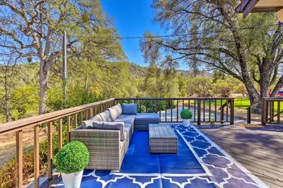 a patio with a couch and chairs on a deck at Lovely Oakhurst Cabin with Deck and Mtn Views! in Oakhurst