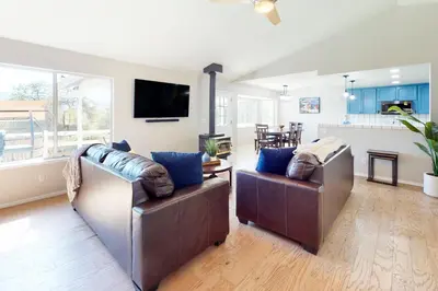 a living room with two leather chairs and a kitchen at Five Oaks Circle Ranch in Oakhurst