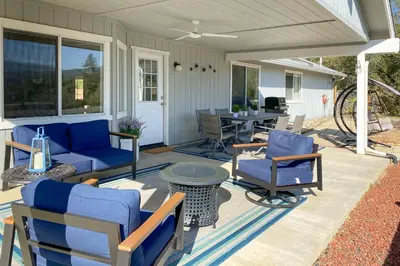 a patio with blue furniture and a table and chairs at Five Oaks Circle Ranch in Oakhurst