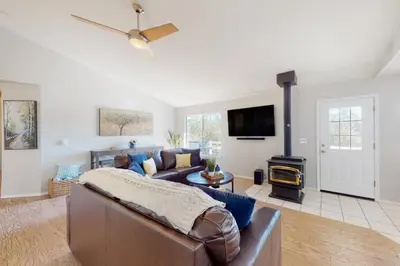 a living room with a leather couch and a fireplace at Five Oaks Circle Ranch in Oakhurst