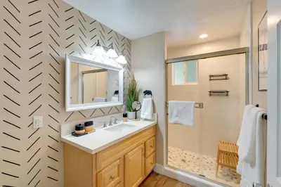 a bathroom with a sink and a mirror and a shower at 12 Mi to Apple Hill Family-Friendly Cabin Retreat in Pollock Pines