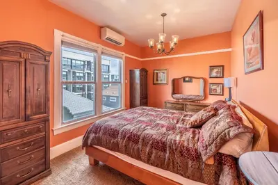 a bedroom with orange walls and a bed and a window at Rustic 2-Bedroom walking distance to Downtown in Reno