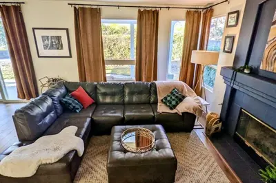a living room with a leather couch and a fireplace at King Bed Quiet Home on Cul-de-Sac Hiking Trails in Roseville
