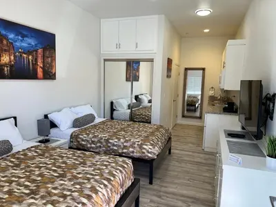 a hotel room with two beds and a kitchen at Villa Alamari Inn and Suites in Kerman