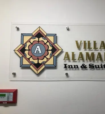a wall with allaunted alamedihadihad sign on it at Villa Alamari Inn and Suites in Kerman