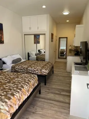 a hotel room with two beds and a flat screen tv at Villa Alamari Inn and Suites in Kerman