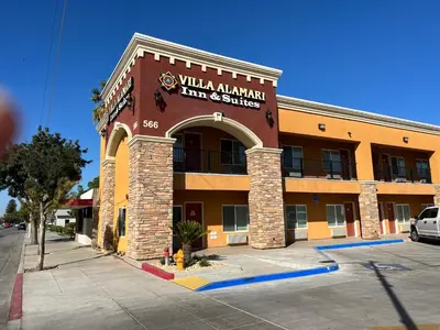 a building with a sign that reads milliken american inn and suites at Villa Alamari Inn and Suites in Kerman
