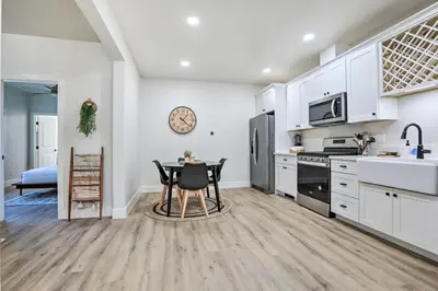 a kitchen with white cabinets and a table and chairs at Boho-Chic Folsom Retreat Walkable Location! in Folsom