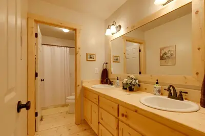 a bathroom with two sinks and a large mirror at Near Hikes Arnold Cabin with EV Charger and Fire Pit in Arnold