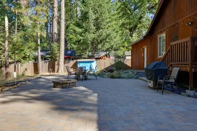 a patio with chairs and a table next to a house at Near Hikes Arnold Cabin with EV Charger and Fire Pit in Arnold