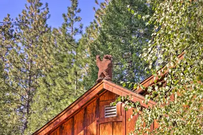 a wooden cabin with a bear statue on top of it at Near Hikes Arnold Cabin with EV Charger and Fire Pit in Arnold