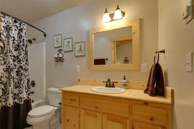a bathroom with a sink and a toilet and a mirror at Near Hikes Arnold Cabin with EV Charger and Fire Pit in Arnold