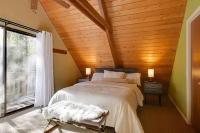 a bedroom with a bed with a wooden ceiling at Spacious Groveland Cabin with Wraparound Deck! in Groveland