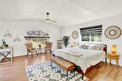 a bedroom with a bed and a desk and two windows at Villa near Yosemite & bass lake w/Hot Tub/EVcharge in Oakhurst