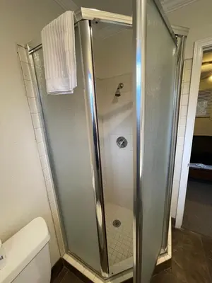 a shower with a glass door in a bathroom at Sierra Woods Lodge in Emigrant Gap