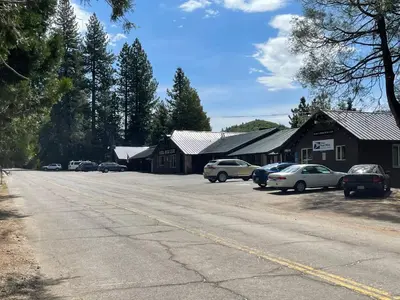 a street with cars parked in front of a building at Sierra Woods Lodge in Emigrant Gap