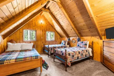 a bedroom with two beds and a tv in a cabin at Jug Handle Hideaway in Arnold