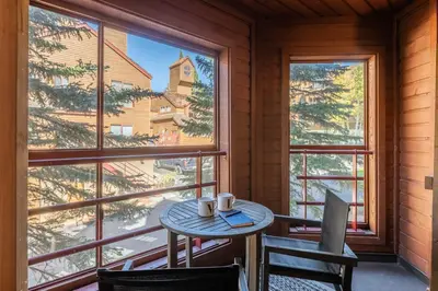 a table and chairs in a room with a large window at Aspen Creek 121 in Mammoth Lakes