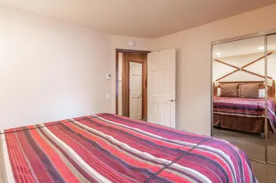a bedroom with a large bed and a mirror at Updated 2 Bedroom and Loft 2 Full Bathroom Woodlands #51Just Steps to Shuttle Close to Golf Course in Mammoth Lakes