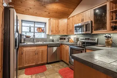 a kitchen with wooden cabinets and stainless steel appliances at Updated 2 Bedroom and Loft 2 Full Bathroom Woodlands #51Just Steps to Shuttle Close to Golf Course in Mammoth Lakes