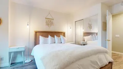 a bedroom with a large white bed and a mirror at Summit #105 condo in Mammoth Lakes