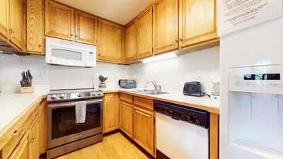 a kitchen with wooden cabinets and white appliances at Lakeview Villas #28 condo in Mammoth Lakes
